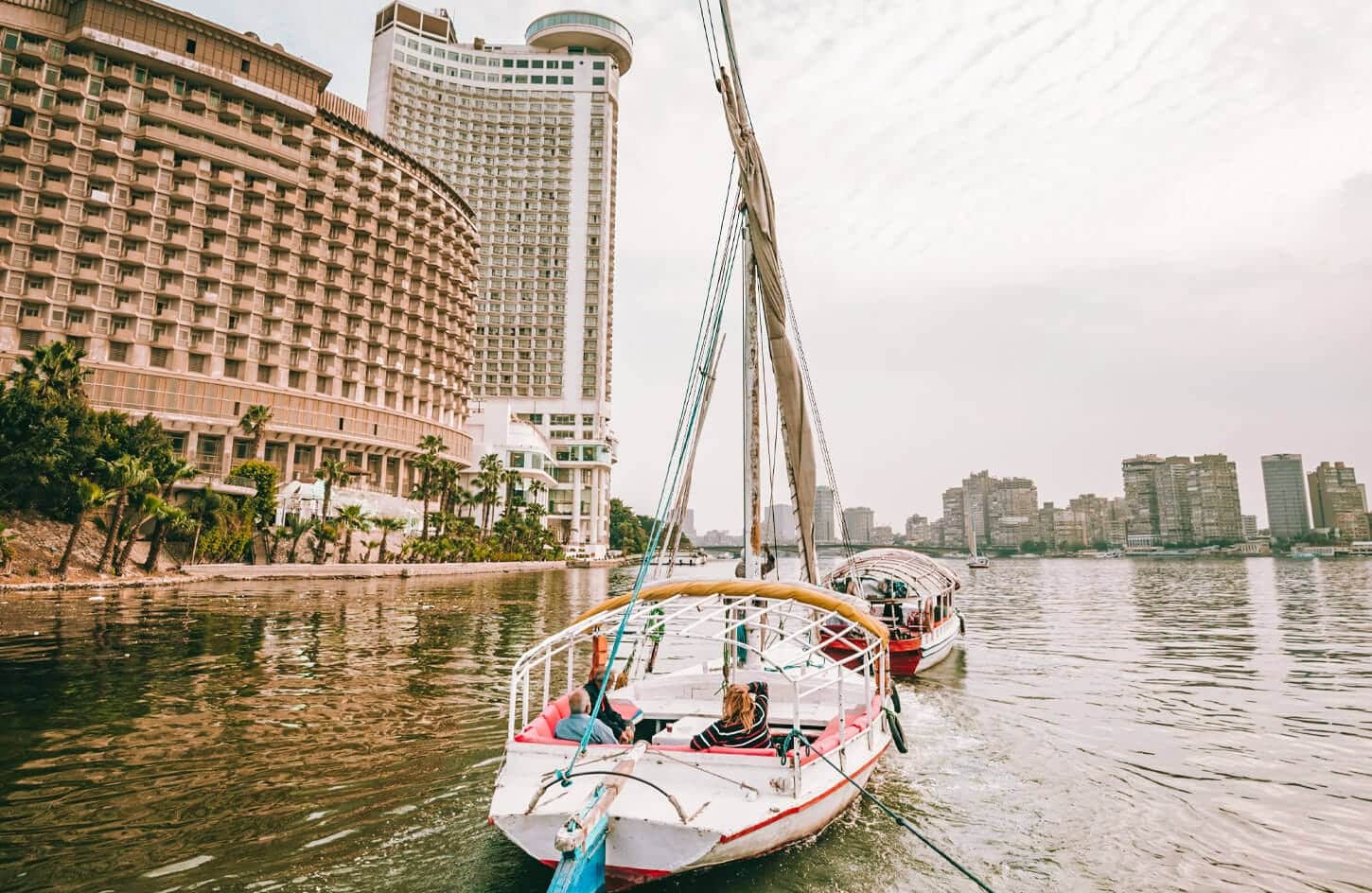 Una feluca naviga lungo il fiume Nilo a Cairo, con paesaggi mozzafiato sullo sfondo.