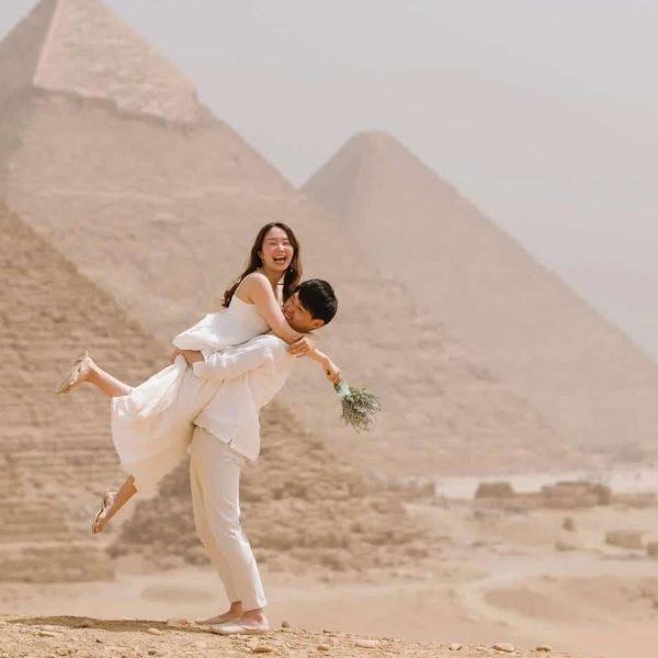 Coppia in luna di miele davanti alle piramidi, momenti romantici.