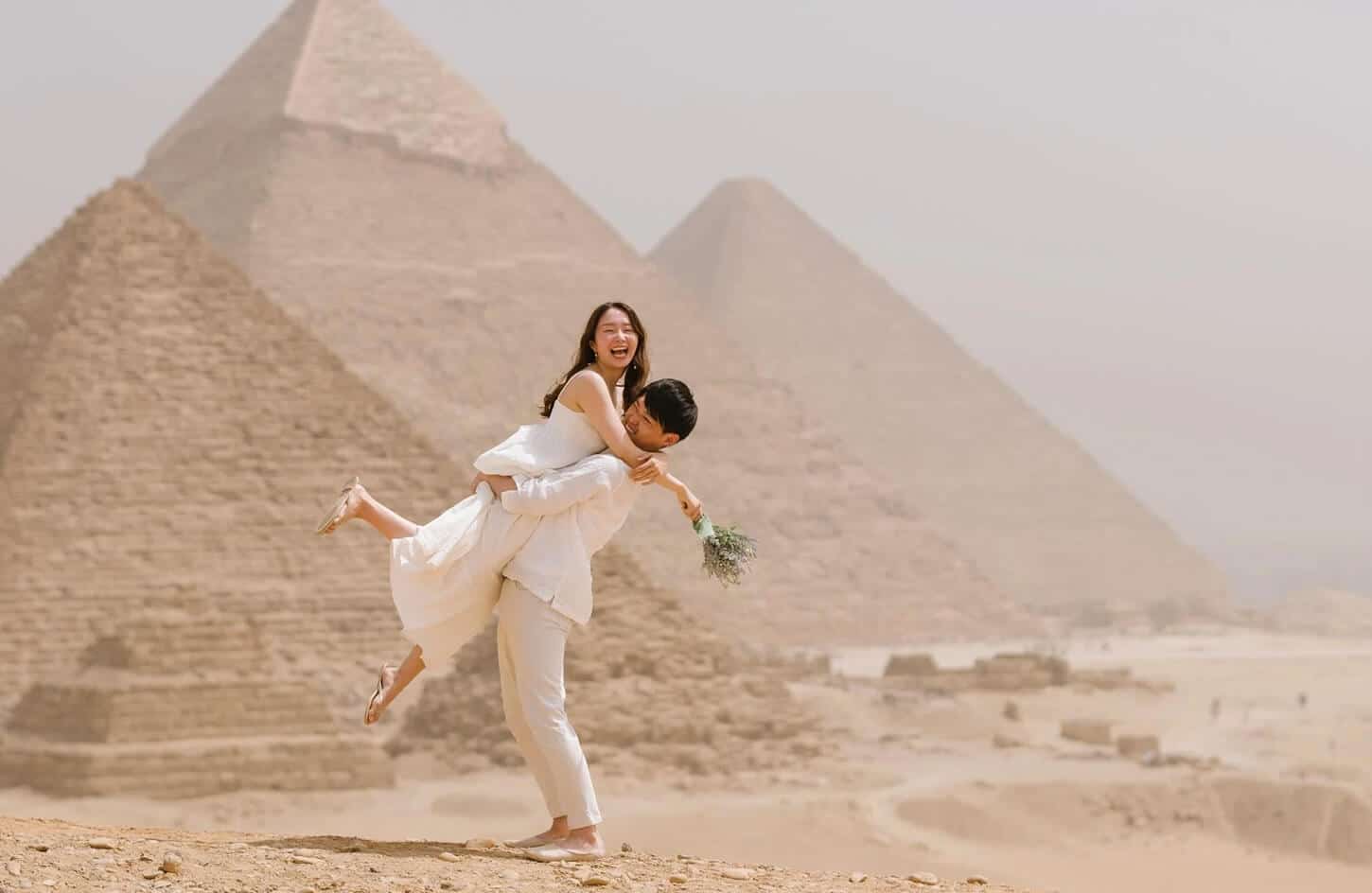 Coppia in luna di miele davanti alle piramidi, momenti romantici.